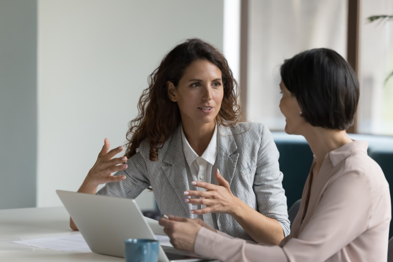 Lawyer showing a comparison chart of fault vs no-fault insurance systems in a meeting with a client