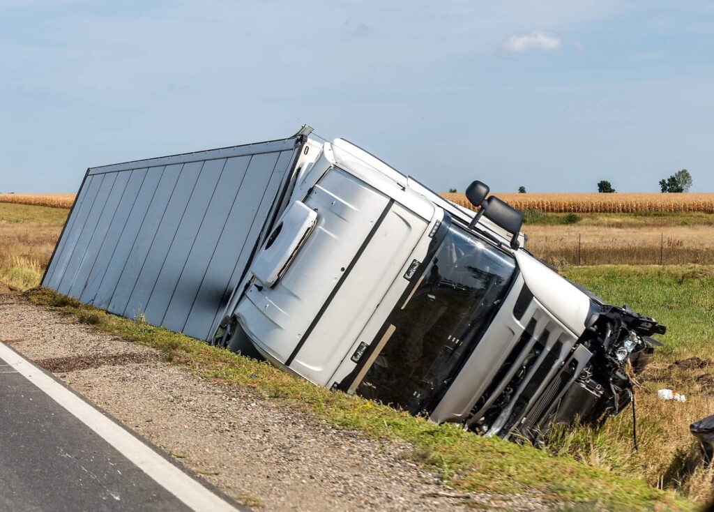 The large truck is in a side ditch after the accident