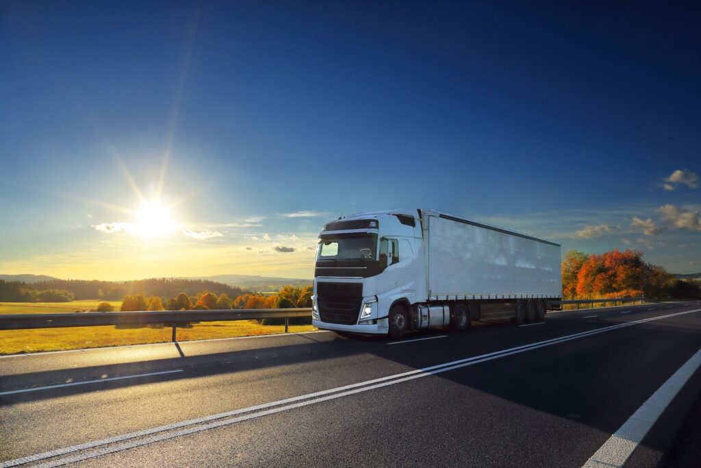 Truck transport by road at dusk and cargo